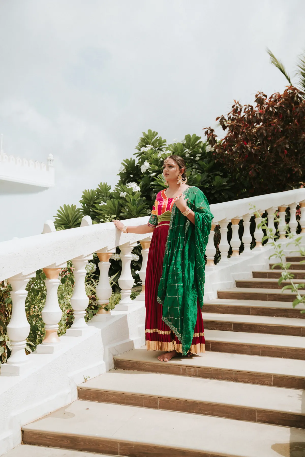 Fashion portrait on a white staircase with a green dupatta